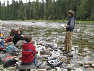 Photograph of teacher and students on a riverbed