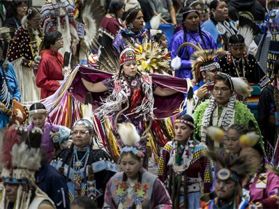 Drummers sitting around a drum at the Kyiyo Pow Wow
