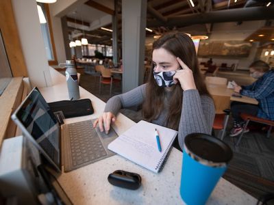 student working on laptop in lounge