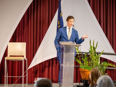 A student standing up on stage speaking to other students