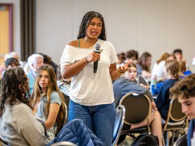 A student speaking to a room full of students
