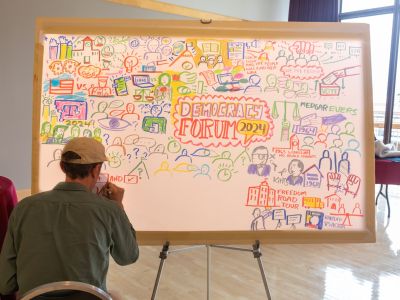 A student filling out a democracy forum poster