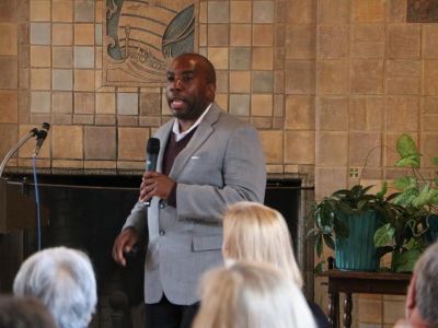 Dr. Goins speaks into a microphone