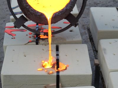 Allen and Evanger pour the molten bronze into a mold.