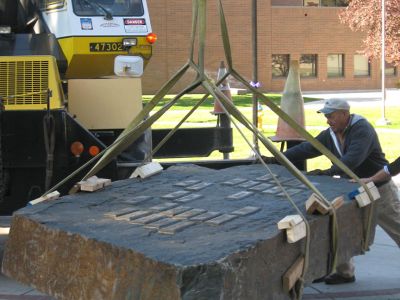 Crews adjust the new monument stone before placing it on the ground.