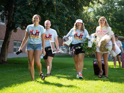 Student workers wearing UM Welcome shirts walking across campus