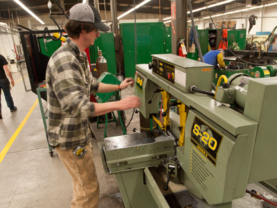 student cutting metal