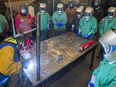 Girls from the GRIT program watch a welding demonstration.