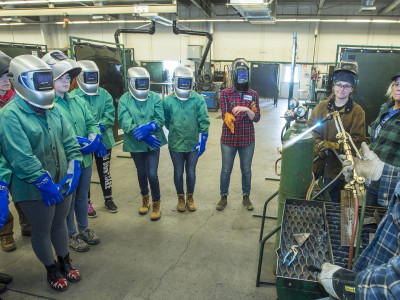 Girls from the GRIT program watch a welding demonstration.