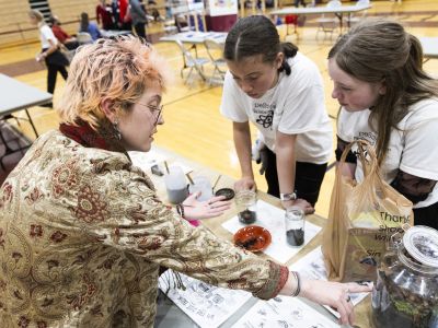 person showing students a sample of soil