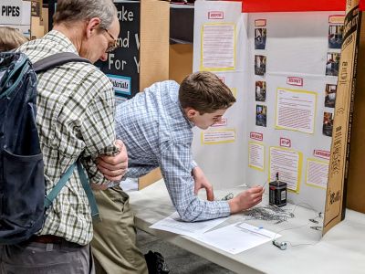 judge inspects a students poster