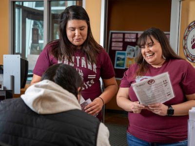 three students talk to AISS coordinator