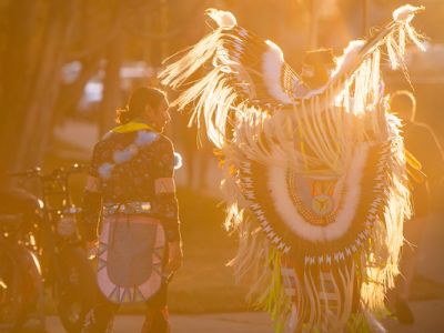 darkened image of an american indian dancer in full costume