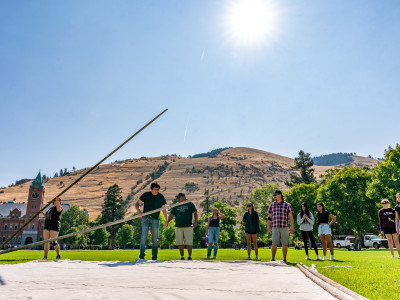 Master's student Ray King fisher teaching first year students how to put up a tipi