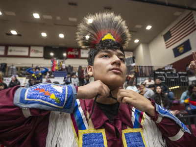 Former student tying regalia to head