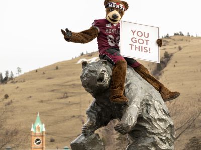 Monte on the Grizzly Statue holding a sign that reads "You got this"