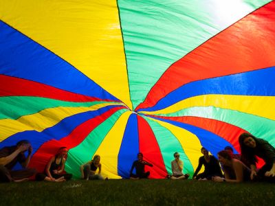 students under a rainbow parachute dome