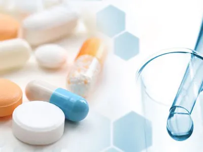 Pills and an eye dropping putting solution in a beaker.