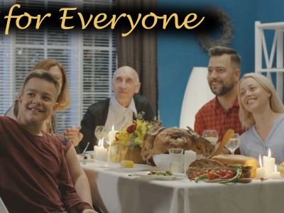 Family with elders at table with holiday dinner; tagline on image says 'for everyone'