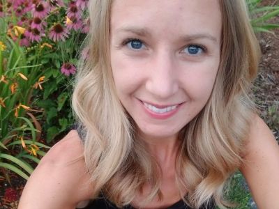 Self-photo of Madison McKenzie in front of purple flowers