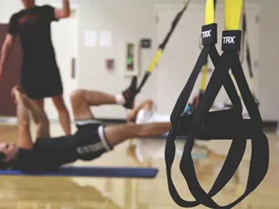 TRX straps hang in a group fitness room