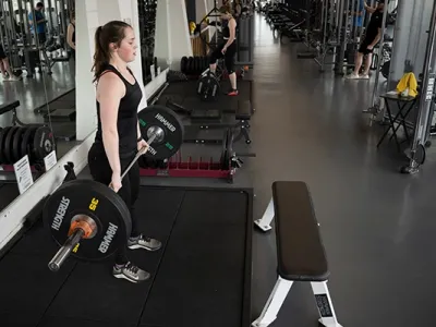 A student lifts weights in the Fitness and Recreation Center at UM