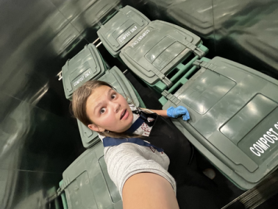 zoe takes a selfie with 6 compost bins in the elevator