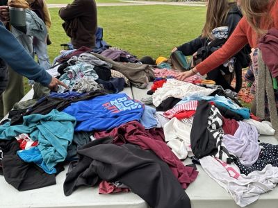people sort through a giant pile of clothes at the clothing swap