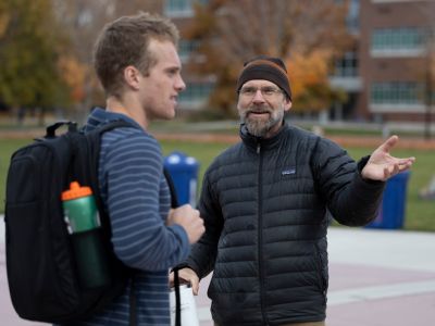 derek educates a man about the zw demonstration with recycle bins in the back