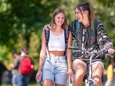 girls hugging while biking