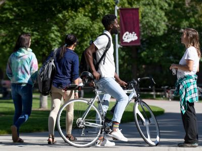 man talking to woman while sitting on bike
