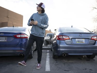 man walking away from parking spot with phone