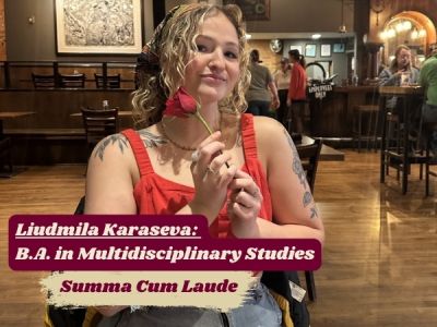 Liudmila smiles, holding a single rose