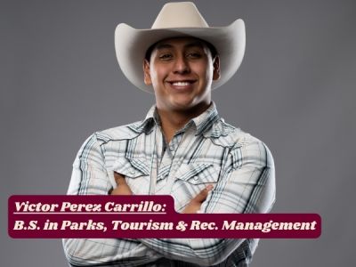 Victor grins at camera with arms folded, white cowboy hat tipped back