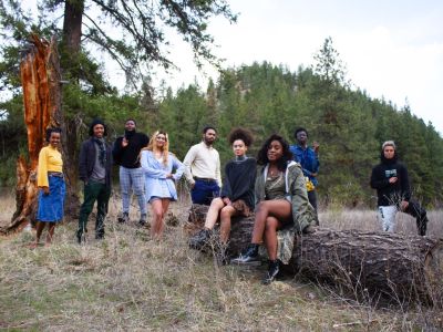 Black Student Union Members stand posed around a fallen log
