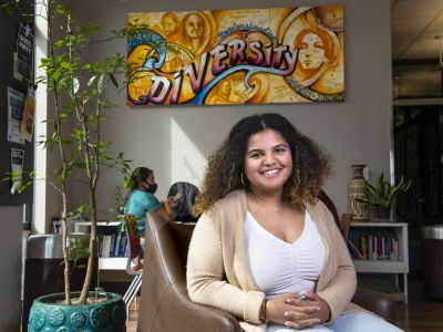 Girl sitting in the branch center with a diversity canvas behind her