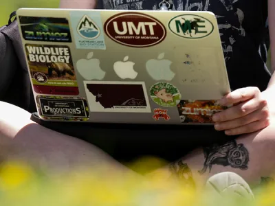 UM student sits outside with laptop open