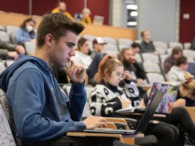 A student works on a laptop in Urey Lecture Hall