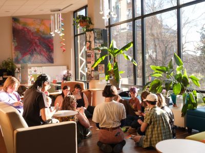 Girl sitting in the branch center with a diversity canvas behind her