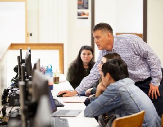 Photo of an instructor and two students in a classroom.
