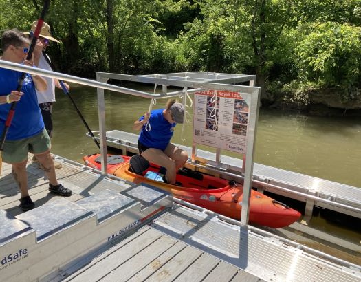 a woman trying to move inside floating boat using assistive technology