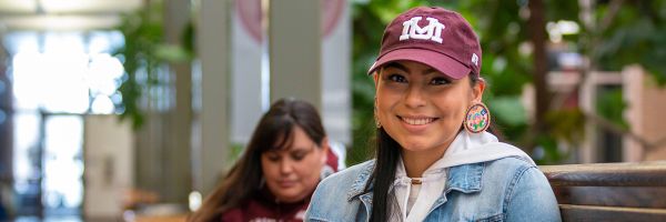 headshot of student sitting inside the UC wearing a maroon UM hat