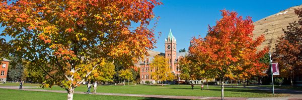 university hall on a sunny day seen from um oval with autumn colored trees