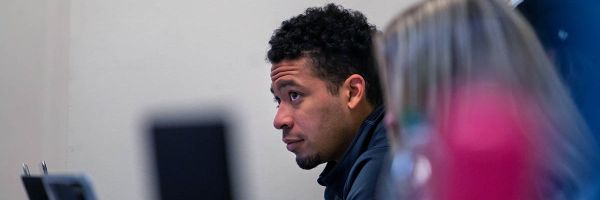 row of students with last one in focus and looking up at professor