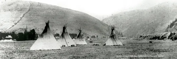 Indian tents (tipis) pitched in front of Hell Gate Canyon, area where Missoula, 51�Թ���, is now situated. Mount Jumbo and Mount Sentinel on either side. Photo credit text in bottom right corner "Archives and Special Collections, Mansfield Library, 51�Թ���".