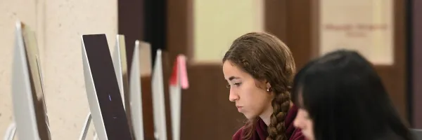 two students working on desktop computers