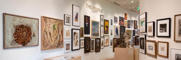 a variety of framed artwork hangs in the Montana Museum of Art and Culture