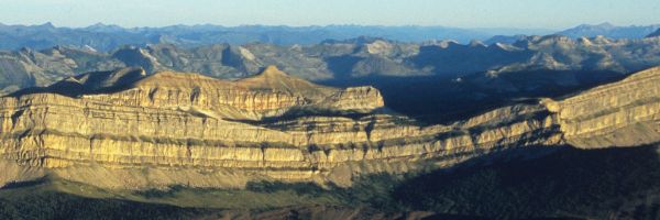 line of mountains with steep drop along the front with more mountains in the background