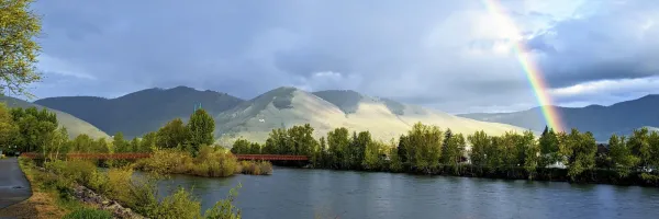 A rainbow arcs over the Clark Fork River in Missoula, MT with Mount Sentinel in the background after rain showers fell on the Missoula Valley.