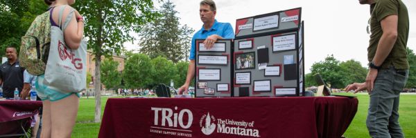 student talking with staff that is working at a Trio table 